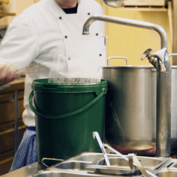 UN Public Service Day The image shows a person, assumingly kitchen staff or a cook, working in a kitchen.